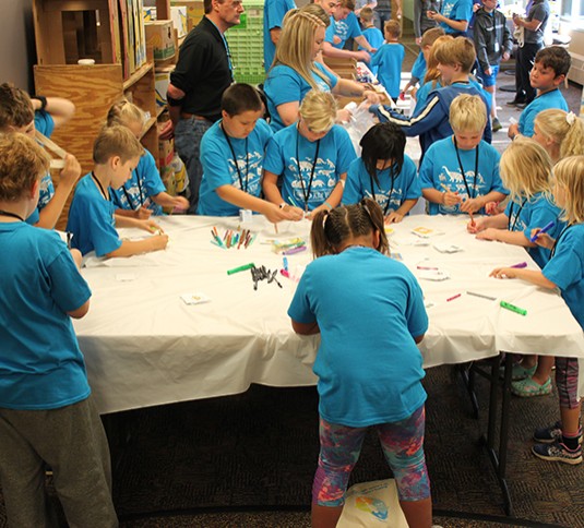 Children making snack packs at Tennant Kids Day