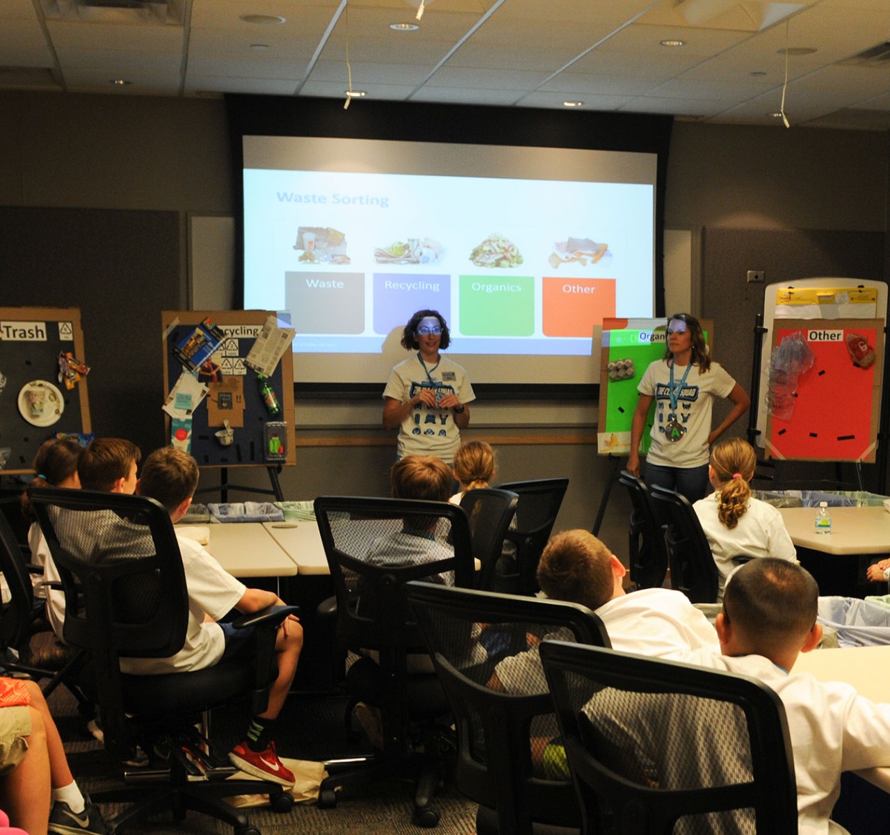 A Tennant employee discusses proper garbage sorting with Kids Day participants