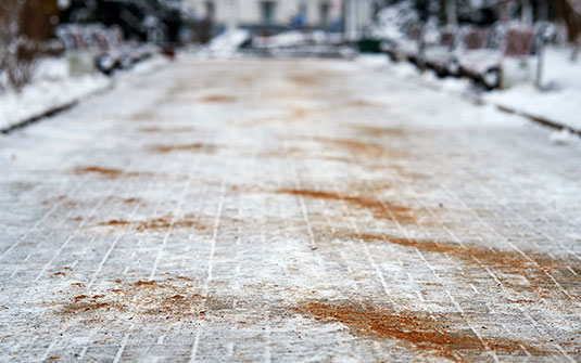brown sand and kitty litter mixture sprinkled on footpath as an alternative to salt