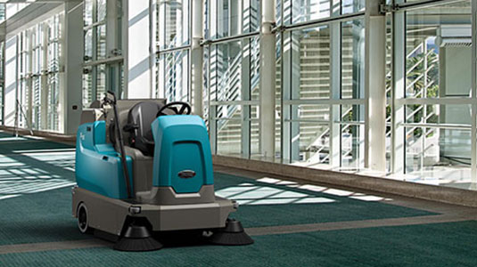 Tennant's new S16 ride-on carpet sweeper cleaning a convention centre
