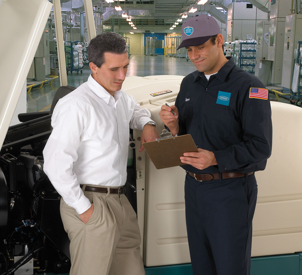 A cleaning equipment service specialist talks to a customer