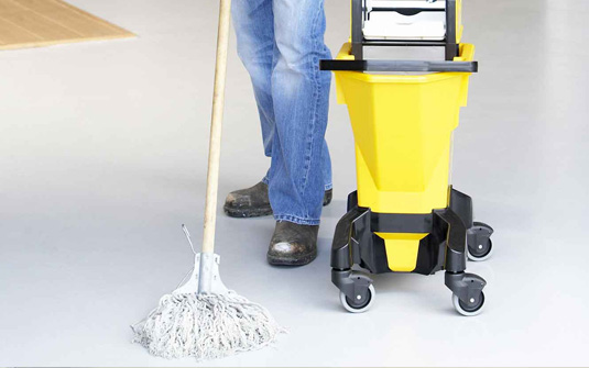 custodial staff using old fashion mop and bucket to clean