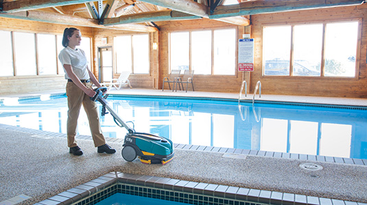 CS5 Walk-Behind Floor Scrubber cleaning near a pool