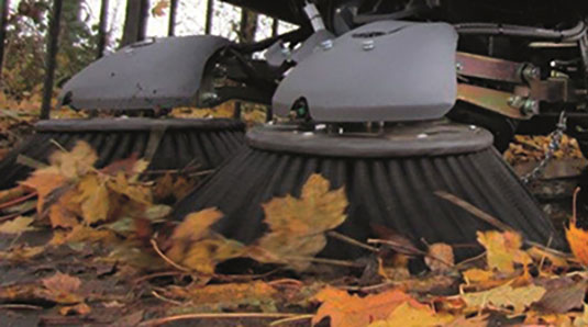 Tennant floor sweeper cleaning leaves outside on sidewalk
