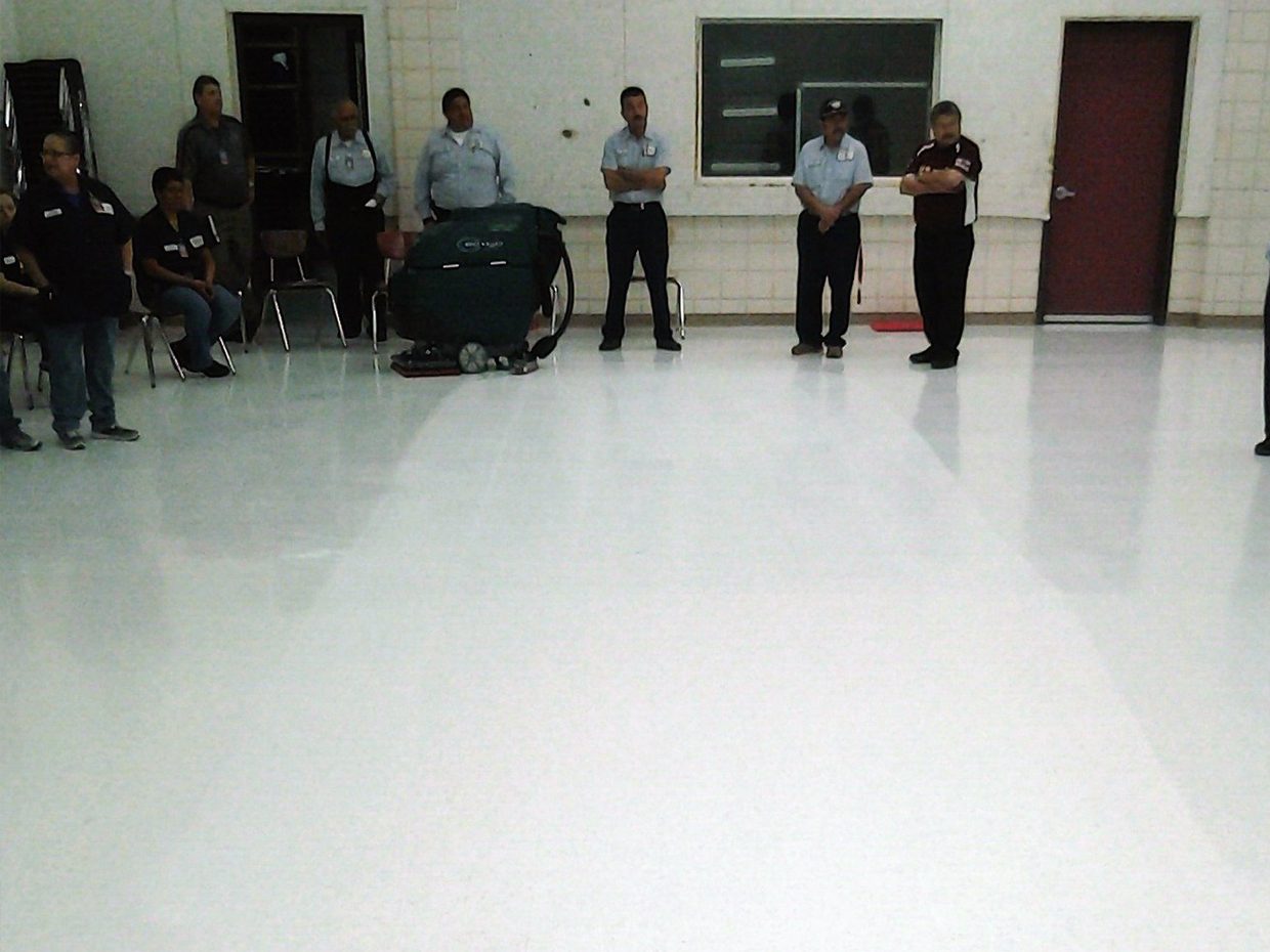 Custodial workers clean floor