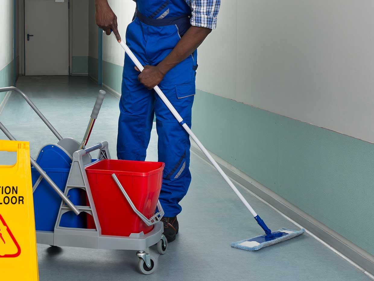 Janitor using microfiber flat mop system